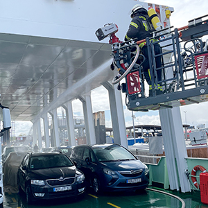 E-Auto mit Brandbegrenzungsdecke mit Löschwasser bespritzt