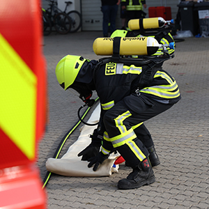 Feuerwehrleute rollen zertifizierte JUTEC Brandbegrenzungsdecke aus